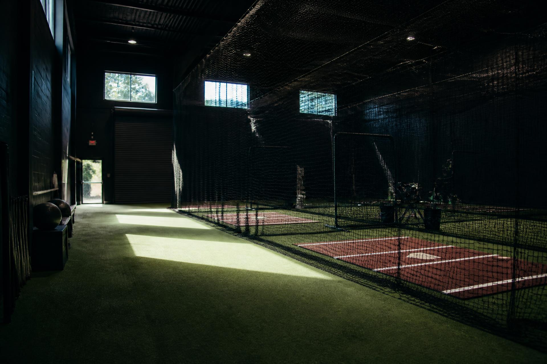 Indoor batting cages with turf lanes at a baseball and softball training facility